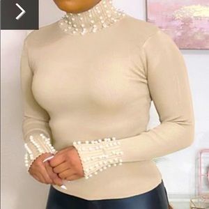 Medium (runs small), beautiful pearl studded turtleneck. Pearls-neck and sleeve